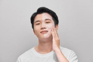 young man has mud clay mask on face photo