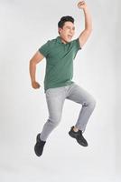 Happy excited cheerful young man jumping and celebrating success isolated on a white background photo