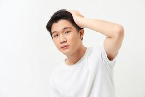 Young handsome man smiling confident touching hair with hand up gesture, posing attractive photo