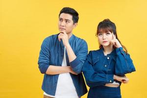 Portrait of his he her she nice attractive lovely curious bewildered couple thinking creating solution learning isolated over yellow color backgroun photo