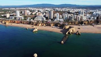 vue aérienne d'une plage, d'un pair et de la ville de portimao video