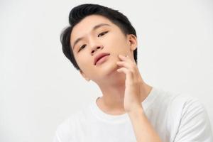 health and beauty concept - beautiful calm man touching his face photo