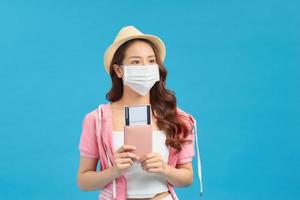 A female traveler in a medical protective mask on her face photo