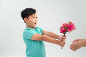 lindo niño sosteniendo un ramo de flores. día de la madre. día Internacional de la Mujer. retrato de un niño feliz sobre un fondo blanco. primavera. foto