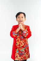 Happy lunar new year. Young Asian boy in ao dai with gesture of congratulation on white background photo