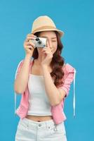 Smiling woman with travel case holding photo camera. Traveler girl isolated portrait.