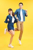 Full length body size view of his he her she nice attractive crazy funky cheerful couple jumping in air having fun fooling rejoicing isolated on yellow photo