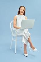 Beautiful student sitting in a chair with a laptop photo