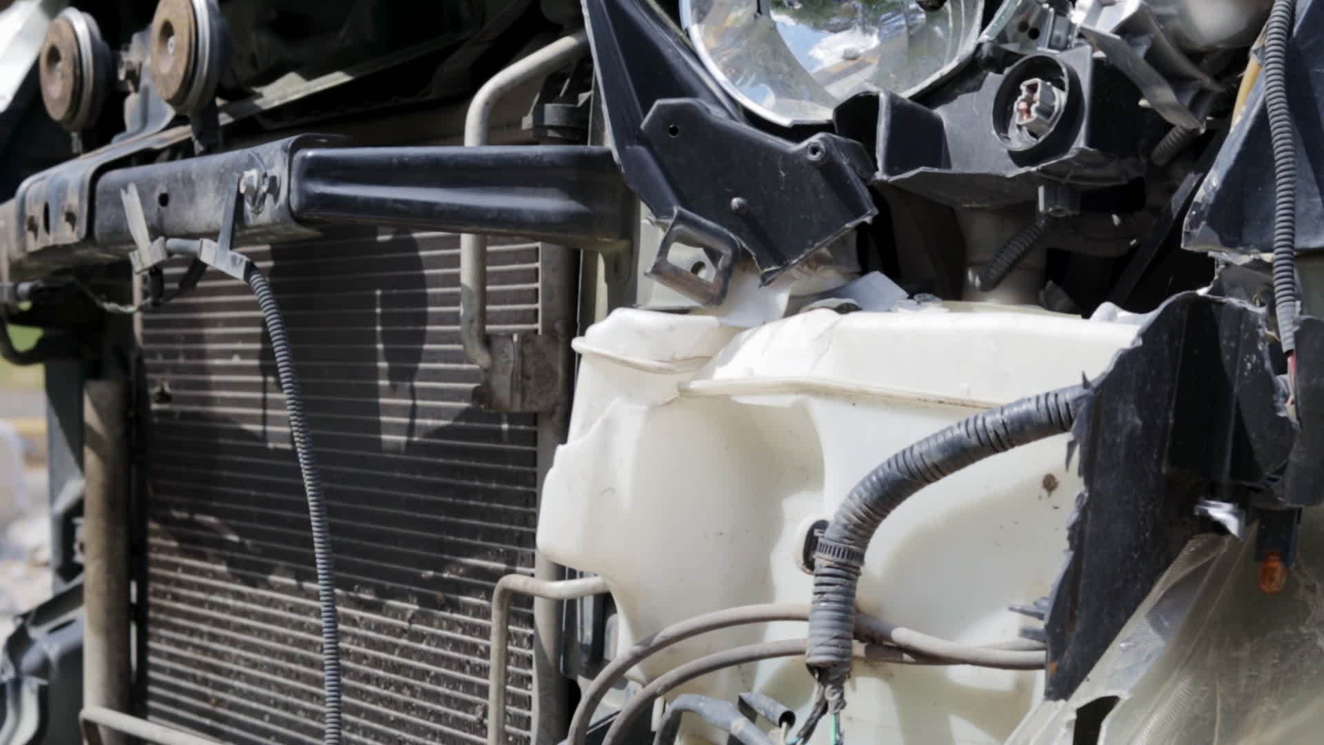 A broken car after an accident is on the side of the road. Close up of