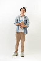 Smiling teenager with a schoolbag standing on wall background photo