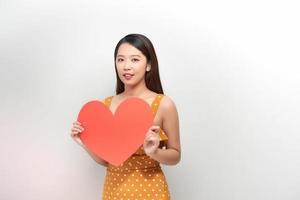 The happy woman holding a heart symbol on the white background photo