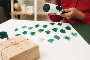 mujer decorando la cubierta de papel presente en navidad. navidad, noel concepto. foto