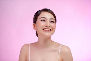 Smiling young asian woman satisfied with her natural beauty photo