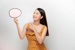 Attractive asian female with empty message box isolated on white background. photo