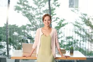 Front view of woman standing at table in office photo