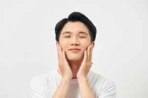 Beauty portrait of half naked handsome young man touching his face isolated over white background photo