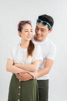 Young couple embracing and posing on white background photo