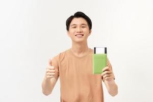 Portrait of a happy young man holding passport and showing thumbs up isolated over white background photo