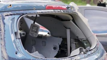 un automóvil después de un accidente con una ventana trasera rota. ventana rota en un vehículo. los restos del interior de un automóvil moderno después de un accidente, una vista detallada de primer plano del automóvil dañado. video