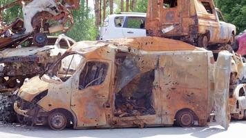 carros após o incêndio. peças de ferro de um carro queimado. carros queimados abandonados ao lado de um campo tranquilo. explosão, resultado de um incêndio. conceito de seguro automóvel. guerra da rússia contra a ucrânia. video