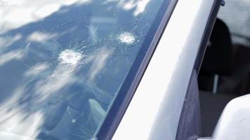 Bullet holes in the windshield of a car. Auto insurance. A car of civilians, with a broken windshield, damaged by shelling. Victims of the Russian full-scale invasion of the territory of Ukraine. video