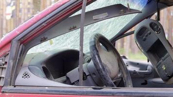 close-up do volante de um carro após um acidente. os airbags do motorista não foram acionados. foco suave. pára-brisa quebrado com volante. interior do veículo. painel e volante pretos. video