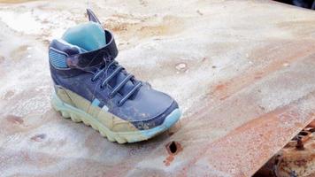 Close-up of children's shoes on a burned-out car after an accident. Boot on the street with cars in the background. Children's shoes after a dangerous road accident. video