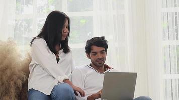 Young couple working on laptop at home on vacation. Working online video