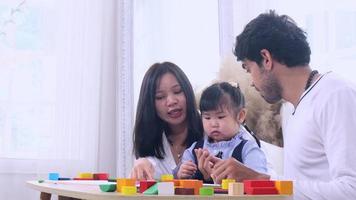famílias asiáticas alegremente jogando quebra-cabeças de madeira. amor, laços familiares calorosos video