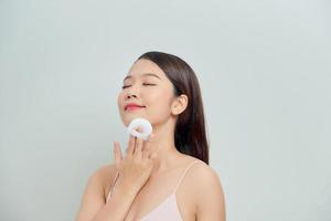 Young lady applying blusher on her face with powder puff, skin care concept photo