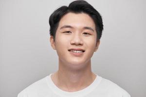 Handsome young man over grey grunge wall with a happy face standing and smiling with a confident smile showing teeth photo