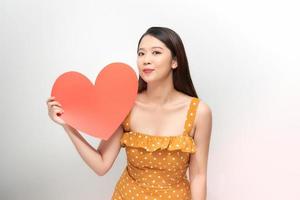 portrait of a pretty woman holding a paper heart on white background photo