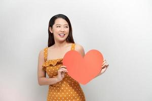 Photo of pretty lady hold hands hugging red paper heart affectionate  isolated on white background