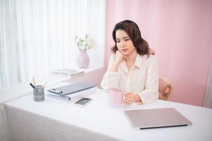 Portrait of young Asian business woman feeling tired at her office. photo