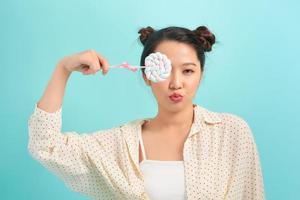 Portrait of young sexy funny fashion girl posing on blue wall background in summer style outfit with lollipop photo