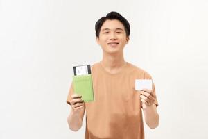 Young asian man is holding a credit card and his passport over white background. photo