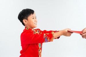 Little Vietnamese boy holding red envelops for Tet. The word mean double happiness. It is the gift in lunar new year or Tet Holiday on isolate background photo