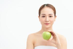 Young woman eating green apple isolated over white background photo