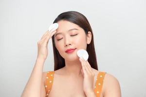 Gorgeous Lady Using Cotton Pads Applying Makeup Remover On Face photo