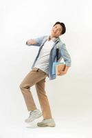 Portrait of smiling young college student with books and backpack against white background photo