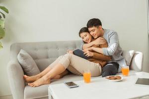 Portrait of young couple reading book sitting on couch photo