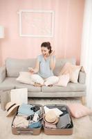 Surprised tourist reading good news on mobile sitting on a couch in the living room at home photo