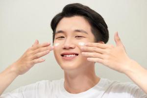 Young man with moisturizer on the face photo