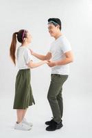 smiling young couple dancing and holding hands, isolated on white photo