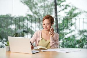 Young woman talking on phone in office photo