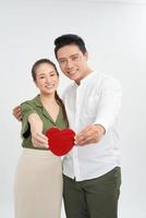 Loving young couple standing in embrace and holding heart shape isolated on white background photo