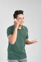 Young handsome man talking on cellphone, excited, rejoicing, isolated on white background. photo
