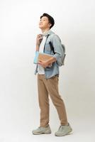 Smiling teenager with a schoolbag standing on wall background photo