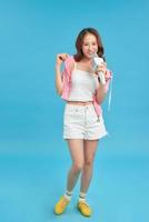 Lifestyle portrait of young cute and happy Asian student girl singing online karaoke song with microphone photo