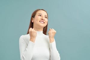 Close up portrait of attractive shouting in winning smiling with raised fists photo